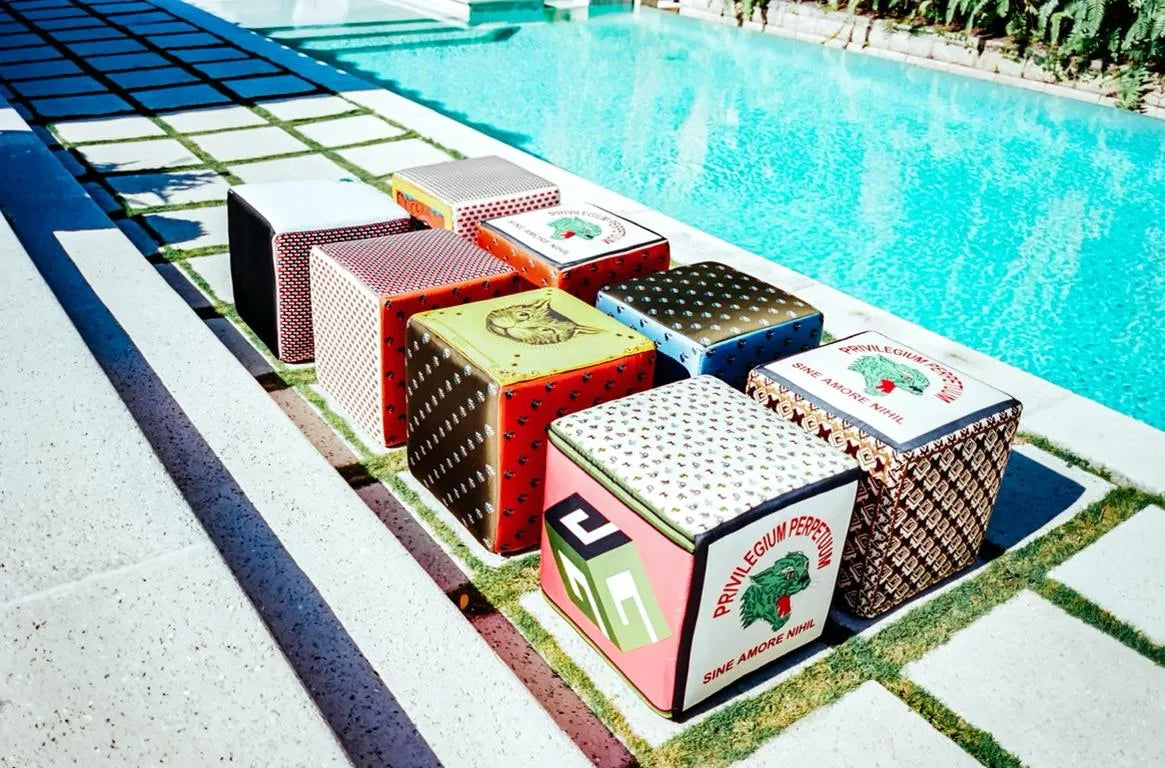 J. Logan Home decor blocks in patterned vintage silk beside a Palm Beach pool