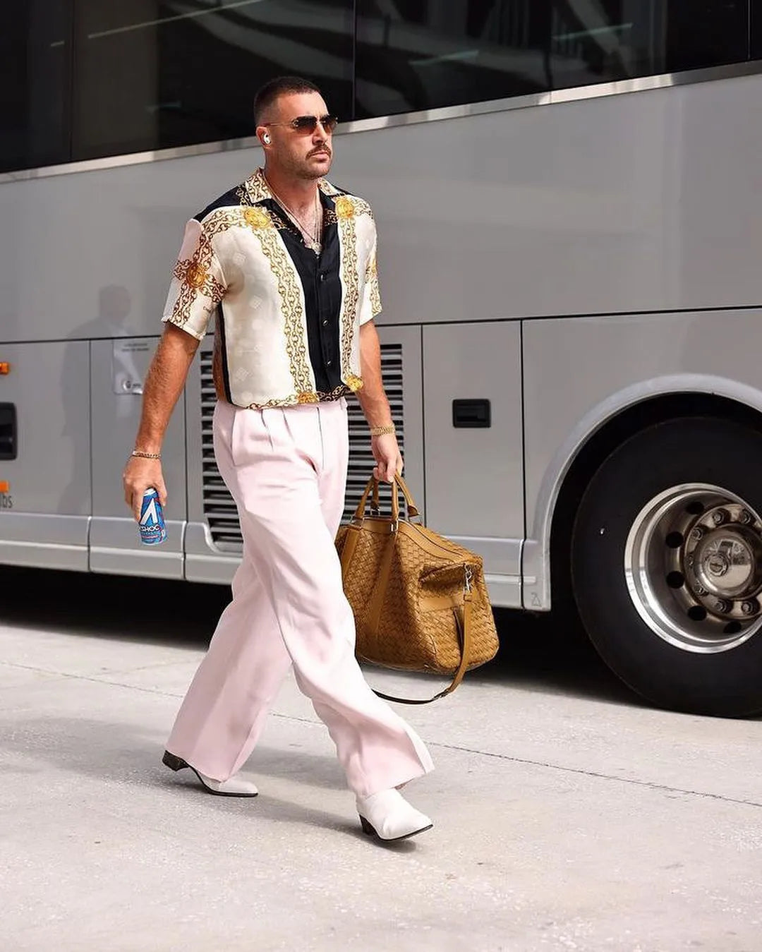 Travis Kelce arriving at a game in a chain-print J. Logan Home silk shirt